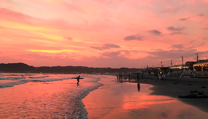 Walking along the beach while watching sunset in the early evening.